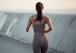 Fitness, running and woman in outdoor exercise in body health, energy or wellness from back. Workout, commitment and girl runner with dedication to morning marathon training, performance or cardio
