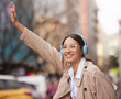 Business woman, headphones and street for taxi, travel or smile with audio streaming subscription. Person, wave and happy in city with waiting for transportation on commute to workplace in New York