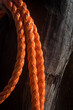 Dettaglio di una corda aranciona legata intorno a un palo di lego