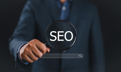 Leinwandbilder - Businessman using magnifying glass focus to SEO icon to analyze SEO search engine optimization for promoting ranking traffic on website and optimizing your website to rank in search engines.