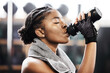 © peopleimages.com - Active, black woman and fitness by drinking water in gym for health or energy from training or workout. Sporty, female person and hydration for wellness or nutrition for routine with cardio