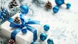 Blue Christmas background with a white gift box tied with a blue ribbon festive New Year decorations in a holiday arrangement on a white backdrop for a greeting card Holiday theme with room