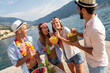 Happy friends having fun with tropical cocktails on beach party. Travel and summer vacation concept.