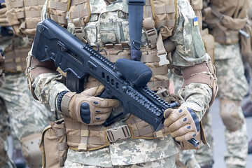 A military man in camouflage uniform with an automatic rifle and the insignia of the Ukrainian army