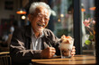 Smiling old man is sitting in a cafe and eating delicious ice cream
