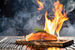 Grilled salmon steak with rosemary on a wooden board with flames over dark background