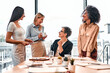 Team of smiling successful business women professionals talking in modern workspace. A group of workers collaborate together and discuss a project.