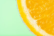 Close up view of a slice of orange in soda water with bubbles. Summer drink concept.