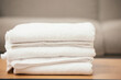 Clean, laundry and soft towel on table for hospitality, cleaning service and white material of fabric. Fresh, textile and pile of linen cloth at home with texture for bathroom, health and hygiene
