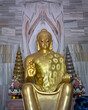 Close up image of Huge golden statue of sitting Buddha outside Thai temple in Sarnath near Varanasi.