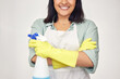 Woman, confident and spray bottle in studio for cleaning, gloves and chemical product or detergent. Female person, arms crossed and white background to tidy, maid and cleaner service for maintenance