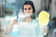 Woman, spray and smile with gloves on cloth in house for cleaning, scrub and dirt on window. Housekeeper, happy and apron with textile or detergent in bottle for dust in home by living room.