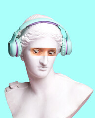 Wall Mural - Antique statue bust with human eye photo elements expressing shock, wearing headphones on blue background. Modern design. Contemporary colorful art collage. Concept of creative vision, emotions.