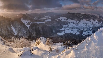Frosty sunrise panorama in beauty mountains. Scenic winter wonderland. Beautiful morning light passes through the clouds