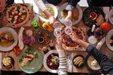 Fototapeta Tulipany - Eating together. Table full of food, from above, wide view. Enjoying food, dining with family, friends.
