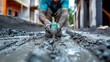 During repairs, a dirty young builder holds a drill perforator against a gray background