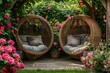 Two rattan cocoon wicker chairs near blooming roses in the backyard in summer