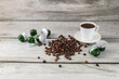 Coffee machine capsules, a cup of coffee and coffee beans lie on a wooden surface