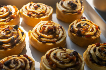 Wall Mural - Uncooked mixed fruit cinnamon rolls dough on a baking tray in preparation for baking