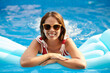 © DragonImages - Happy woman in sunglasses spending time in swimming pool on sunny day