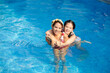 © DragonImages - Happy Vietnamese mother and daughter swimming in pool on sunny day