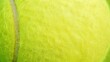 A close up of a bright green tennis ball with a white line.