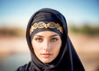 Portrait of a beautiful and sensual muslim young woman in traditional islamic clothing black niqab with golden pattern.