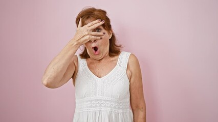 Canvas Print - Shock-peeking middle age woman in dress over pink background