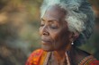 Grateful Senior African American woman closing eyes in Spiritual contemplation standing outside, close-up face of one black elderly gray hair lady in 80s feeling presence of GOD