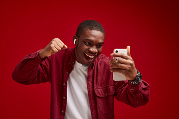 emotional man african appearance with phone in hands technology communication joy