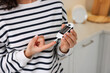 Diabetes. Woman checking blood sugar level with glucometer in kitchen, closeup. Space for text