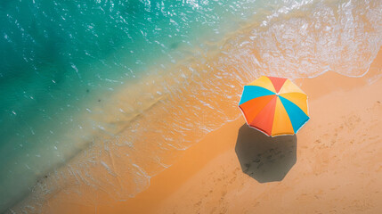 Poster - Aerial view of a vibrant beach umbrella on a tranquil sandy shore next to the sea