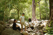 Group of three Asian friends backpacking,two men and one woman, have a good relationship, hikingcamping in the middle of the forest at waterfall and streamsummer time trip.Vacation Lifestyle concept