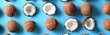 © Hryhor Denys - A collection of coconut halves arranged neatly on a vibrant blue background in a flat lay pattern