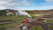 Geothermal power station in Icelandic landscape, steaming chimneys in the valley on a bright sunny day, aerial view. Energy, industry and sustainability concept.