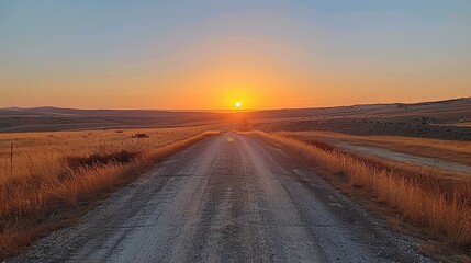 Aufkleber - A road with a sun setting in the background. The road is empty and the sky is clear