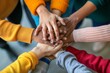 © saranya - Group of friends with hands stacked one on top of another, friendship, support, togetherness. Multiethnic businesspeople with hands touching on top of each other