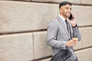 Poster - Coffee, smile and businessman with phone call in city for news, travel or consultant listening to contact. Mobile, drink and Indian professional on wall space for conversation, network or negotiation