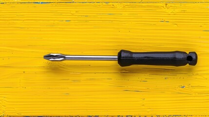 Poster - A screwdriver resting on a wooden table, suitable for DIY and construction projects