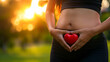 Woman making hand symbol with heart shape on stomach, Female hands forming heart shape for health and self love for wellness and training, Woman hands pregnant making shape heart on her belly