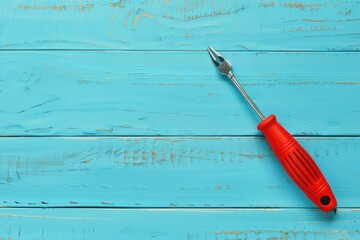 Wall Mural - A red screwdriver placed on a blue wooden table. Suitable for DIY and construction projects