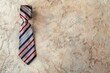Classic red, white, and blue striped tie on elegant marble surface. Perfect for fashion or business concepts