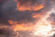 Dramatic stormy sunset sky with cumulus clouds and sun rays in blue-orange tones. Seagulls fly upward in the corner