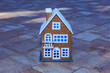 Beautiful toy two-story house with blue light in the windows on the background of paving slabs