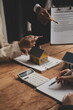 © Sutthicha - Real estate agent and Sales manager team analysis pricing of rental lease contract of sale purchase agreement, concerning mortgage loan offer for and house insurance.