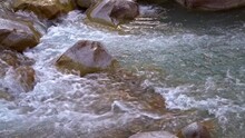 Turbulent Flow Of A Mountain River Running Amidst Red Boulders Of Granite. Azure Blue Mountain Water, Medium Close-up Panoramic Shot. Mountain River View.