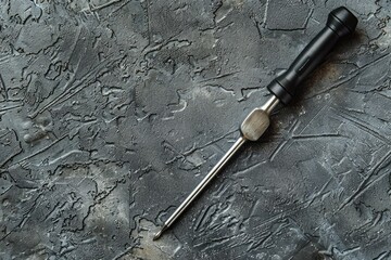 Poster - A screwdriver resting on a metal surface. Perfect for industrial and construction themes