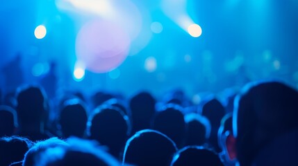 Canvas Print -   A crowd of people at a concert, facing a stage bathed in a bright blue light