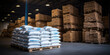Within the vast confines of the hangar warehouse, the space is occupied by large white polyethylene bags, indicative of the logistical operations of industrial firms.