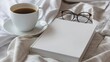 a white book mockup, accompanied by a steaming cup of coffee and a pair of glasses resting on a rumpled bed.